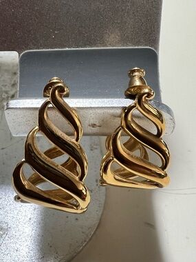 Vintage Monet gold tone earrings with wavy open basket design. 1” long stud back